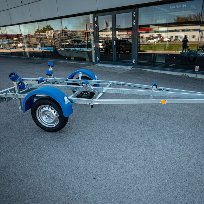 Neptun Navy 750 båttrailer med blå kölrullar och blå stänkskärmar, snett framifrån