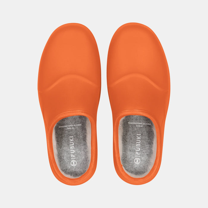 Ett par Fubuki Nozawa i orange sedda uppifrån med mjukt foder och Fubuki-logotyp på innersulan