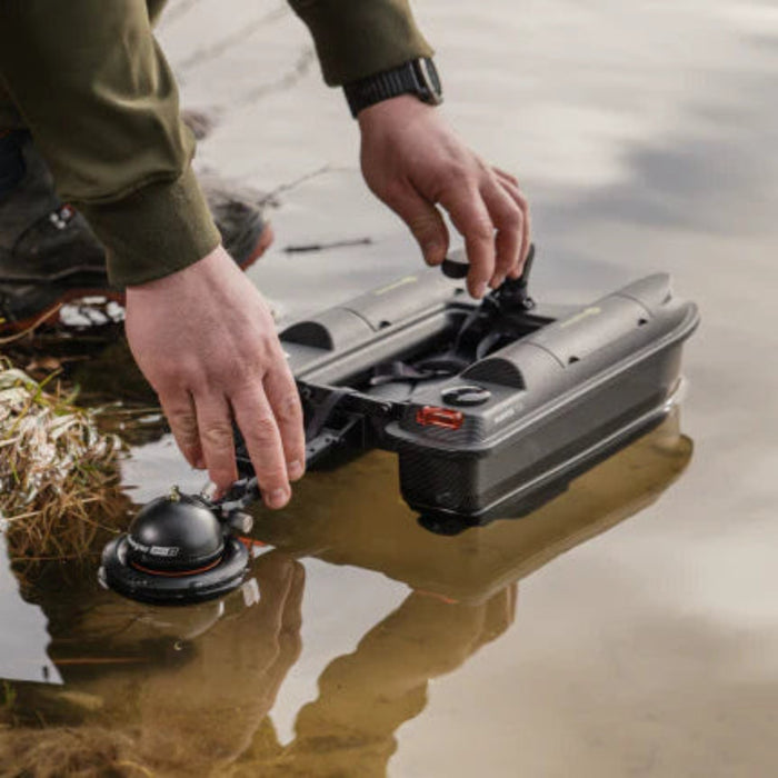 En hand monterar Deeper ekolod i Bait Boat Sonar Holder på en betesbåt vid vattenkanten